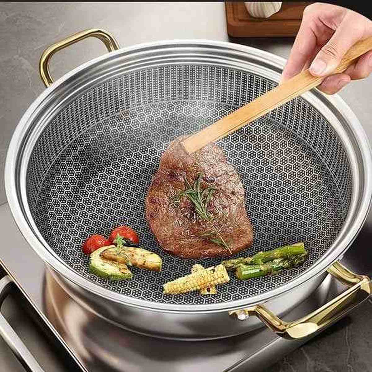 Gros plan de l'intérieur d'un faitout montrant un steak en train de saisir sur un revêtement texturé en nid d'abeille avec des légumes grillés.