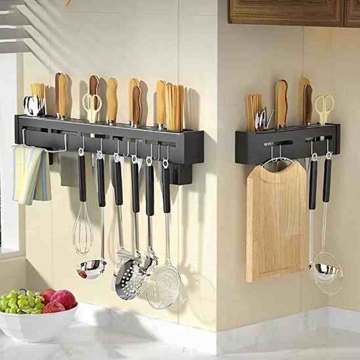 Double barre magnétique porte-couteaux en acier inoxydable fixée au mur d'une cuisine, supportant des couteaux, des ustensiles et une planche à découper.