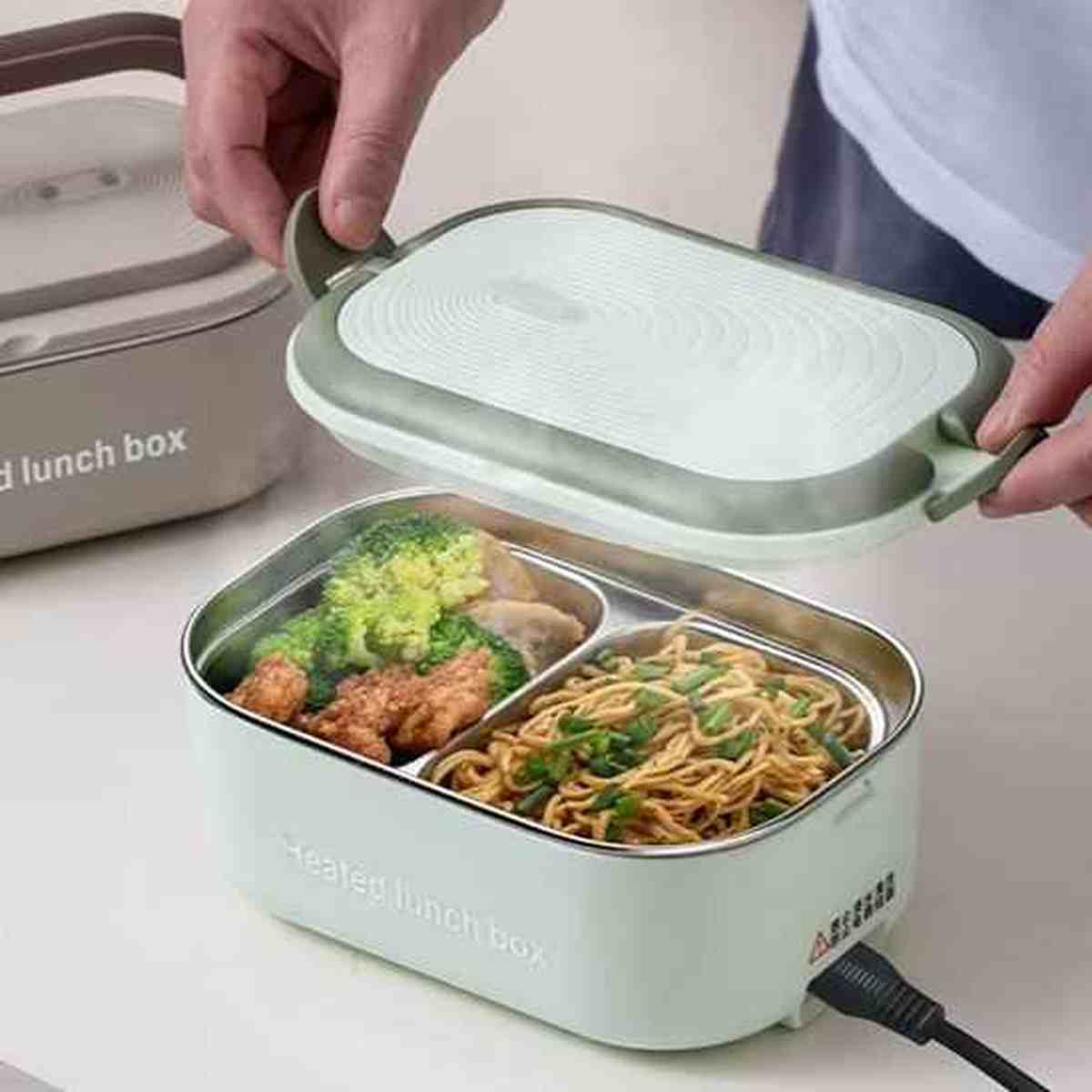 Lunch box électrique BureauGourmet ouverte révélant un repas chaud fumant avec viande et brocolis, idéale pour déjeuner au bureau