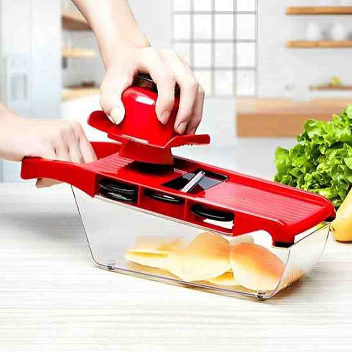Mandoline de cuisine rouge polyvalente avec poussoir de sécurité pour trancher des légumes avec précision.