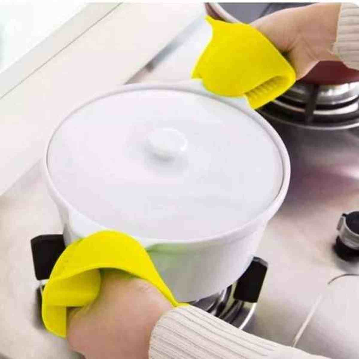 Mini manique en silicone jaune ThermoShield utilisée pour soulever le couvercle d'une marmite chaude sur une cuisinière.