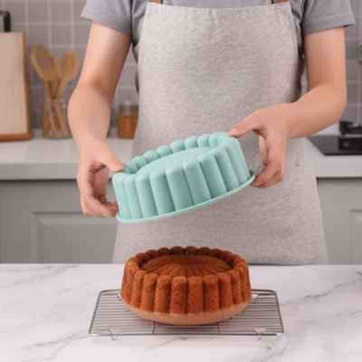 Démoulage parfait d'un gâteau moelleux avec le moule en silicone FlexiPâtissier bleu, montrant sa flexibilité et son revêtement antiadhésif.
