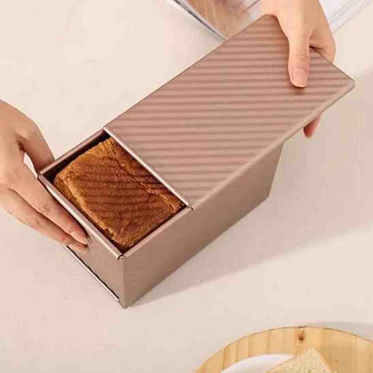 Moule à pain de mie PâtissiPro avec couvercle coulissant en métal bronze, idéal pour obtenir une forme carrée parfaite et une croûte moelleuse.