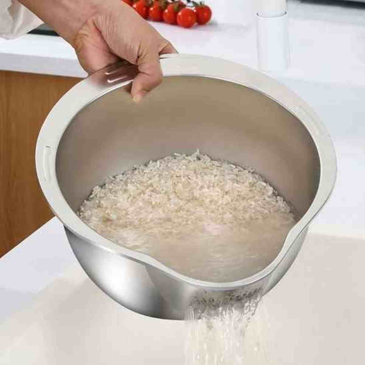 Passoire en acier inoxydable ergonomique de grande capacité, posée sur une table en bois avec un fond de cuisine flouté.