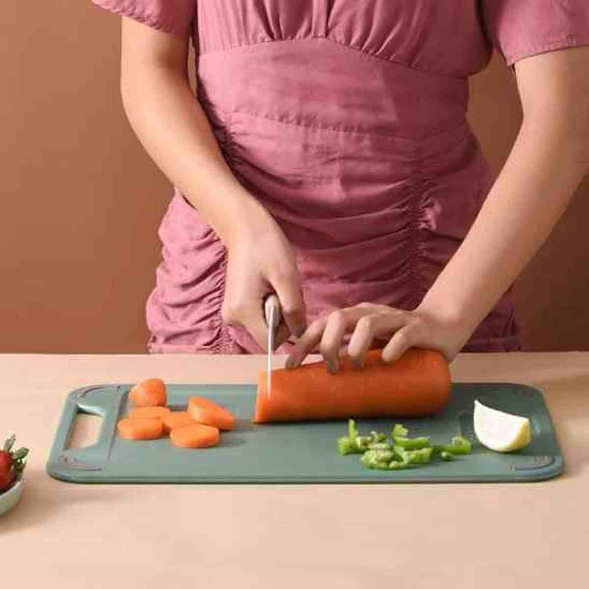 Découpe de légumes sur la planche à découper robuste grise, montrant la surface stable et anti-glissante en action
