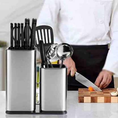 Chef cuisinier utilisant un couteau à côté de l'organisateur en acier inoxydable contenant couteaux et ustensiles de cuisine.