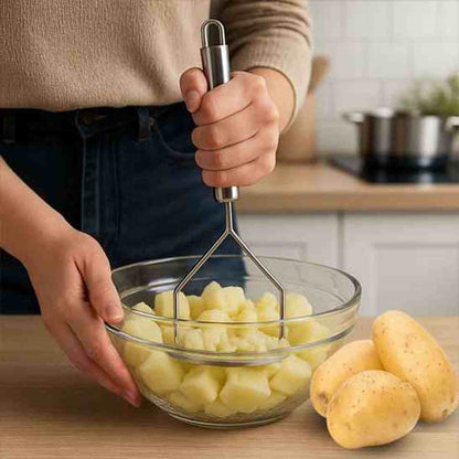 Personne utilisant le presse-purée en acier inoxydable ultra résistant pour préparer une purée onctueuse dans un bol en verre
