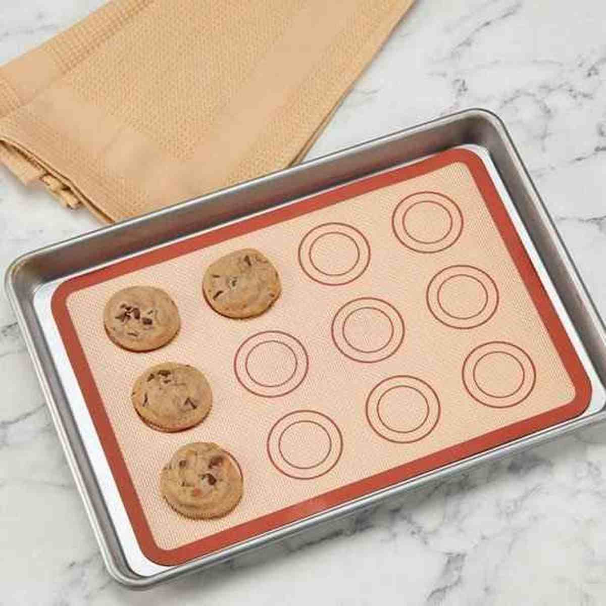 Cookies aux pépites de chocolat cuits sur le tapis de cuisson en silicone PâtissiPro, illustrant une cuisson uniforme sur une plaque de four.