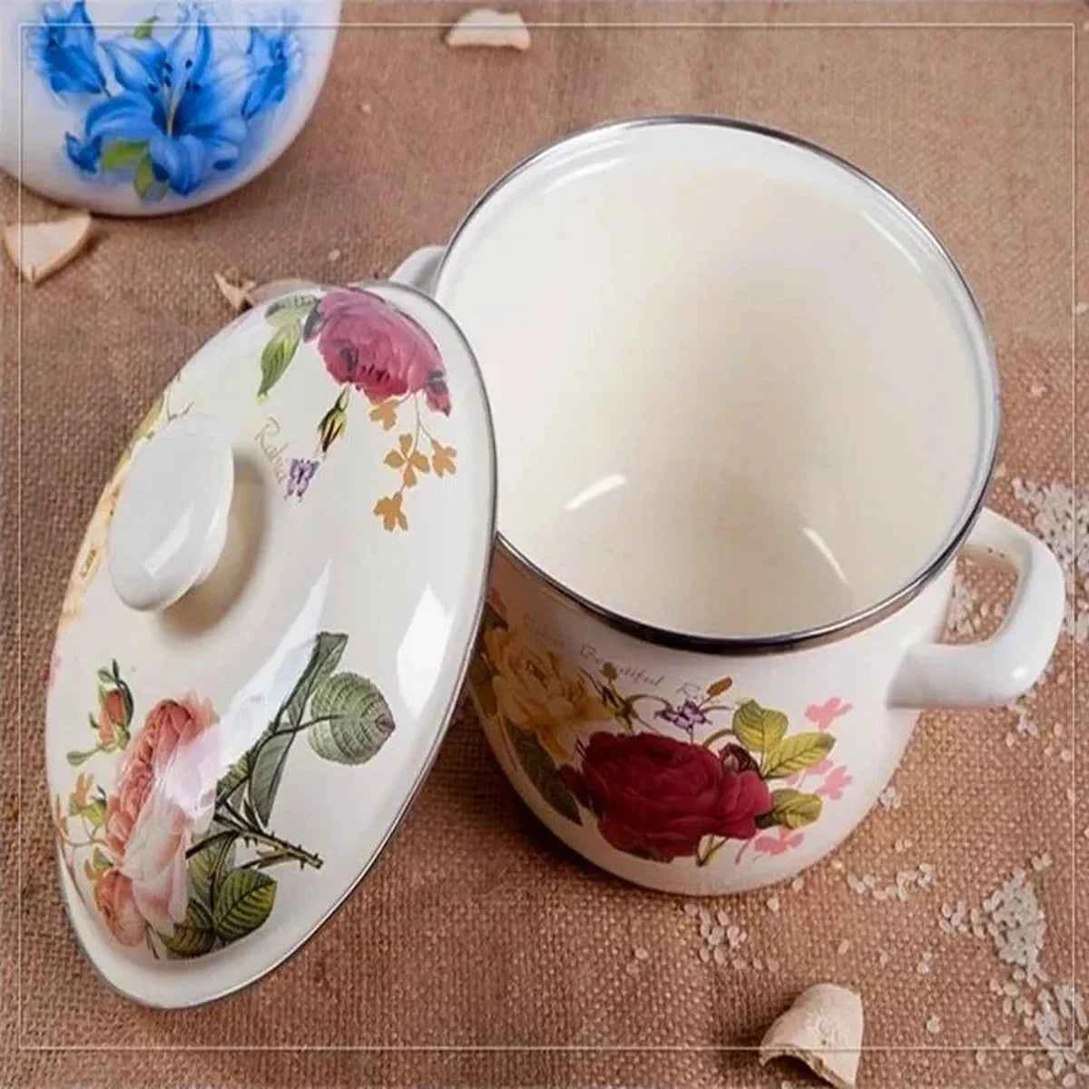 Vue rapprochée de l'intérieur d'une casserole en céramique blanche avec son couvercle floral assorti posé sur le côté.